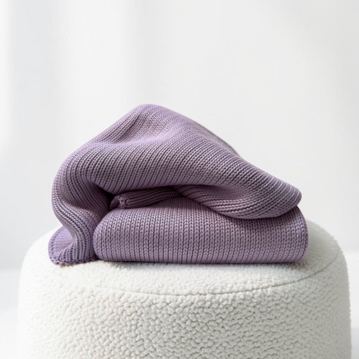 Woven Woven 3.0kg Jacaranda Purple kids bamboo weighted blanket folded on a cream boucle ottoman.