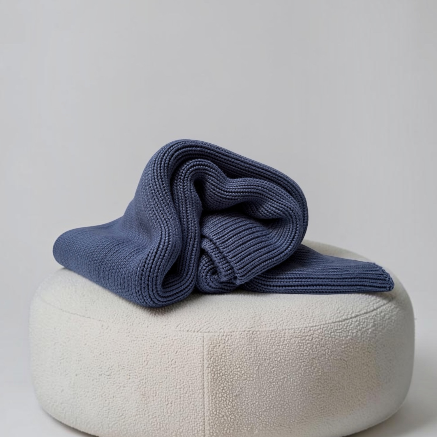Woven Woven 3.0kg Slate Blue kids bamboo weighted blanket featuring a bead-free. Draped on a cream boucle ottoman.